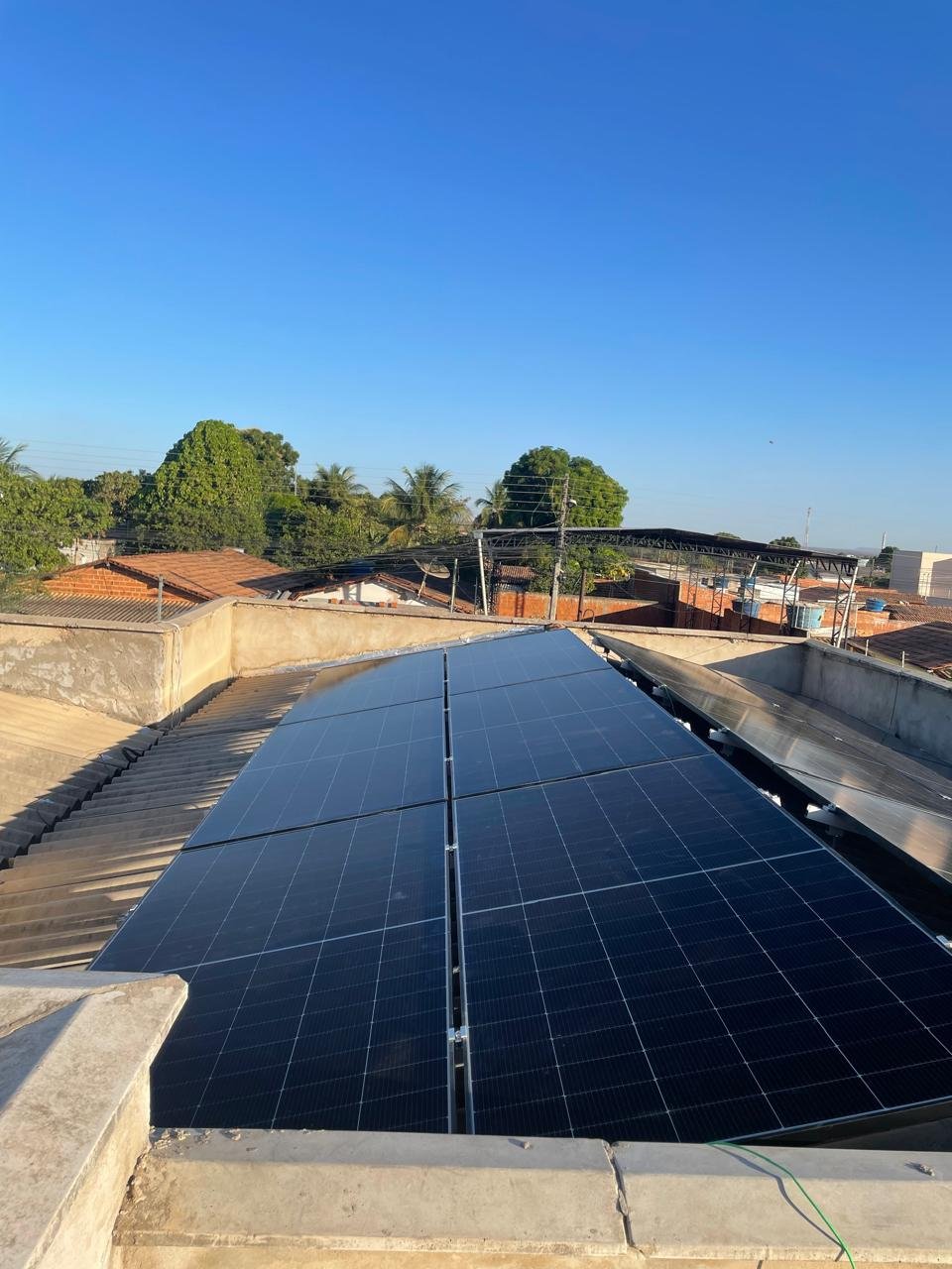 Painéis solares em telhado residencial com céu azul