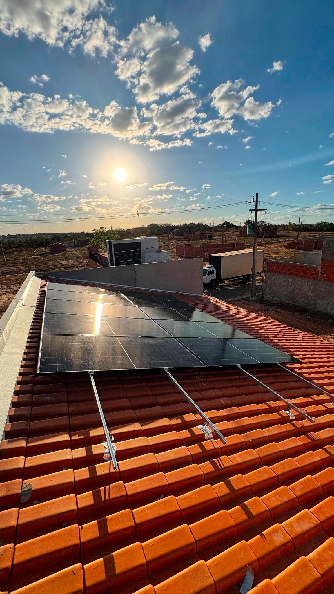 Placas solares em telhado ao pôr do sol